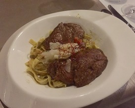 Beef tenderloin on fettuccine with a creamy and spicy green "coop" Sauce