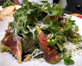 Leaf salad with arugula, baby spinach, figs, parmesan, cedar nuts and poppy seeds