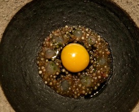 Quail egg gently cooked in roasted bone marrow cured mutton and charred onions 